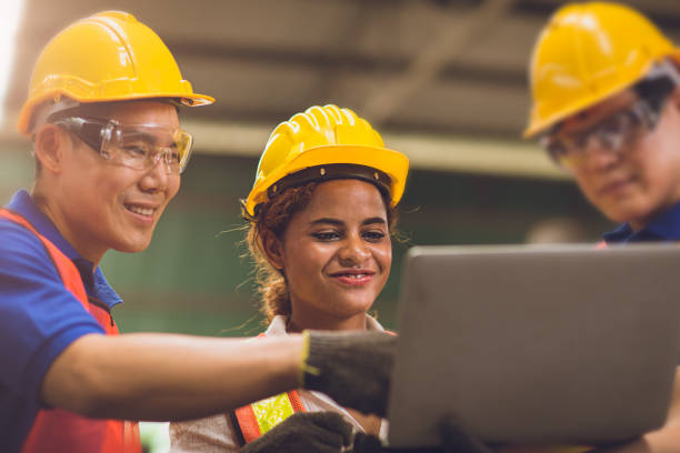 istock smart woman engineer working around with men team mix race work together in heavy industry looking and discussion problem on laptop computer. 1285604894