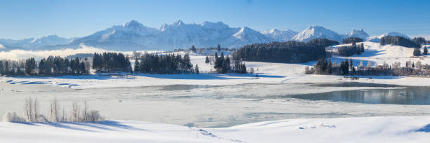 istock panoramic landscape at winter with alps mountains in Bavaria 1285604969