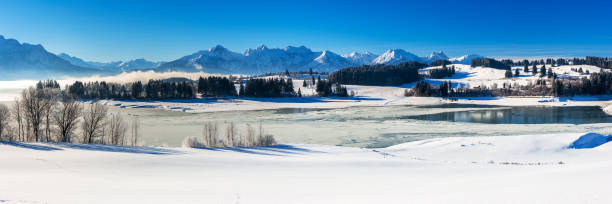 istock panoramic landscape at winter with alps mountains in Bavaria 1285605068