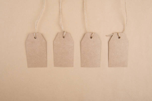 istock Four tags kraft paper for packaging hanging from a rope on a kraft paper background 1285606462