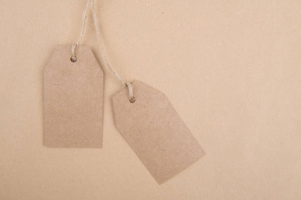 istock Two tags kraft paper for packaging hanging from a rope on a kraft paper background 1285606463