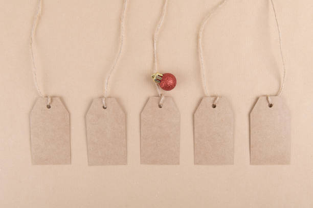 istock Five tags for packaging hanging from a rope decorated with a red Christmas ball on a kraft paper background 1285606467