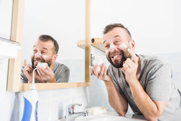 istock Man applying moisturizer cream in bathroom 1285606550
