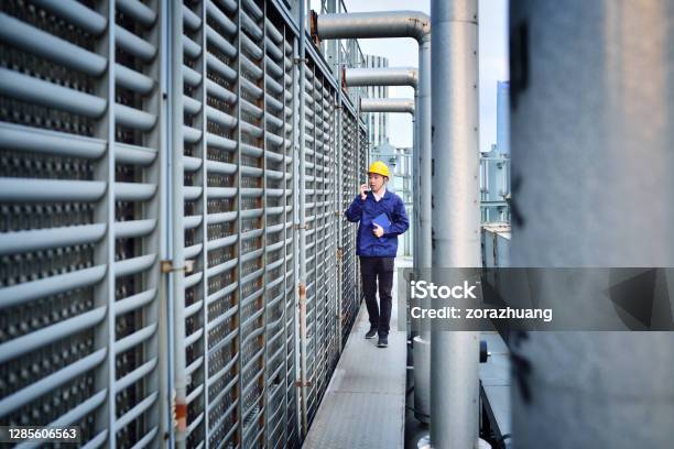 One Males Engineer Examining At Pipeline Stock Photo - Download Image Now - Cooling Tower, Chemical Plant, Chemistry
