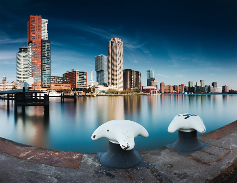 Long exposure panoramic image of Rotterdam skyline at the Rijnhaven harbor, mooring posts