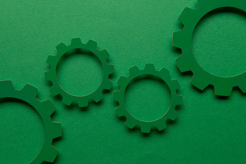 Green paper gears over the green.