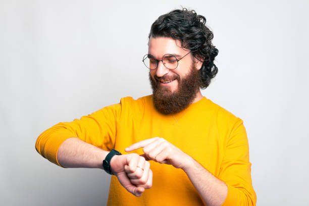 istock Young man is smiling and looking at his watch 1285609712