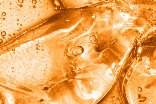 close up macro texture of gel liquid with oxygen bubbles toned close up macro texture of gel liquid with oxygen bubbles toned trendy color marigold serum sample stock pictures, royalty-free photos & images