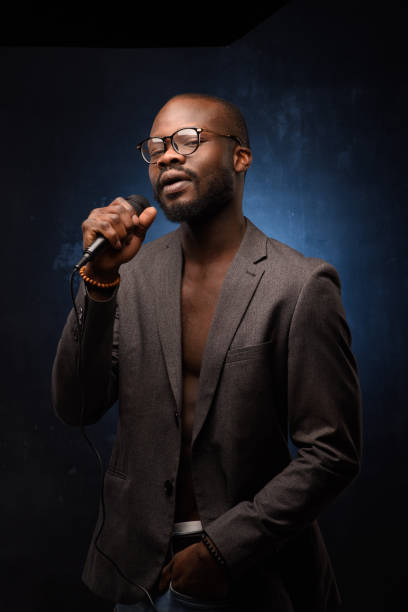 istock A black African American is emotionally singing into a microphone. Close-up studio portrait. 1285613942