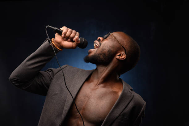 istock A black African American is emotionally singing into a microphone. Close-up studio portrait. 1285613968