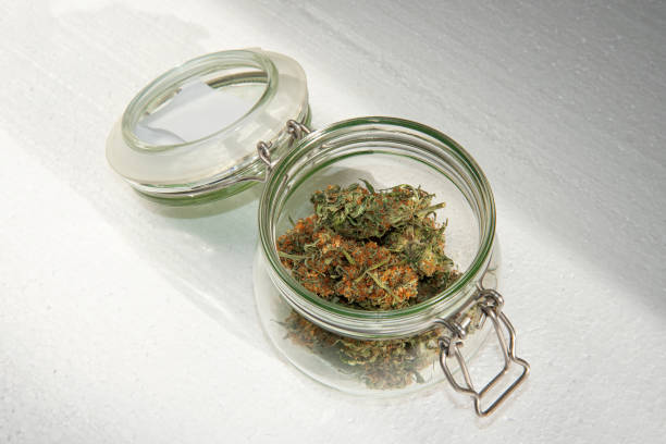 istock dried buds of marijuana in an open glass jar 1285614008