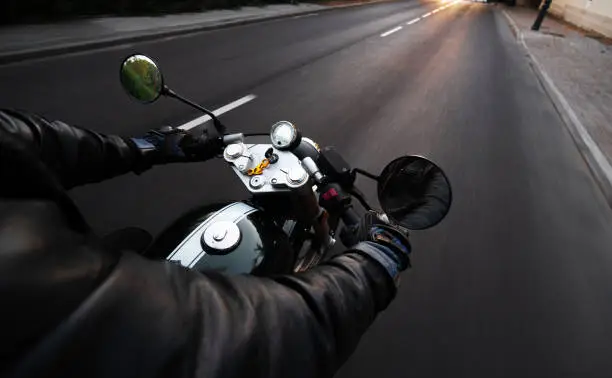 Photo of point of view of driver on a motorcycle on the road driving through the city speed and traffic
