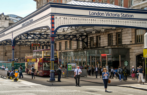 Waterloo station is a central London terminus on the National Rail network in the United Kingdom.  The image shows the main arrival and departure hall with several commuters.