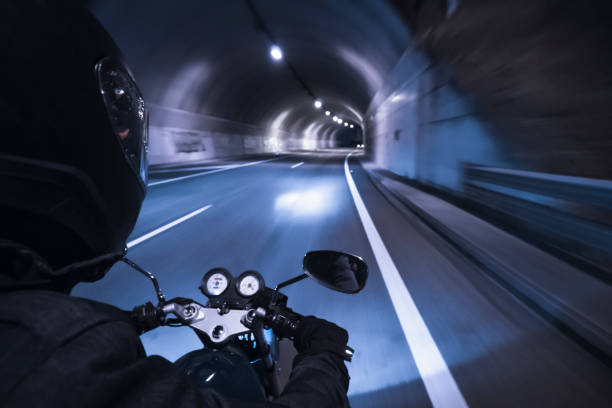 istock biker driving motorcycle with black helmet and motion effect at night entering a tunnel driving traffic 1285615973