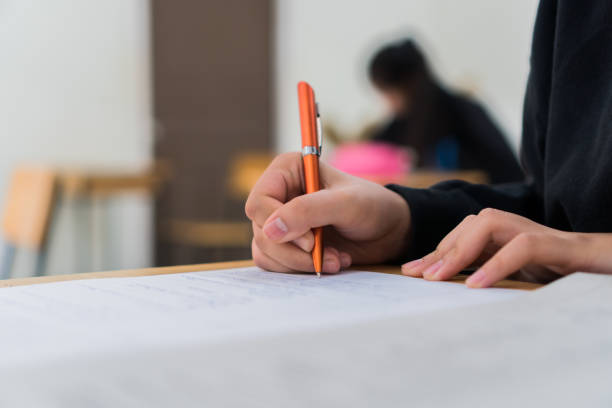 istock Hands Student testing in exam on exercise taking at high school or university in test room. Writing document exams at campus classroom, back to school and evaluation measurement in education 1285620910