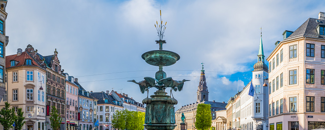 The historic 19th Century Stork Fountain in Amagertorv square surrounded by the stores along the popular Stroget shopping street in the heart of Copenhagen, Denmark’s vibrant capital city.