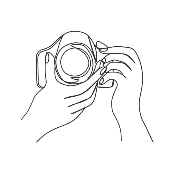 Hands holding camera. Isolated line art. Hands holding camera. Drawn in one line on a white background. Isolated stock vector illustration. graphic print photos stock illustrations