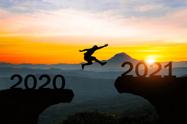 istock Man jump silhouette between year 2020 and 2021 new year concept.