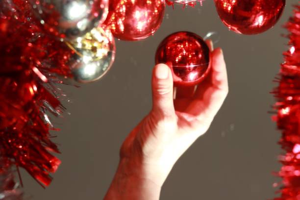 istock Christmas bulbs and women’s hand 1285628866