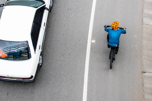 disparo aéreo de un ciclista siendo superado por un coche en la carretera entre bogotá y la calera en las montañas de colombia - overtake fotografías e imágenes de stock