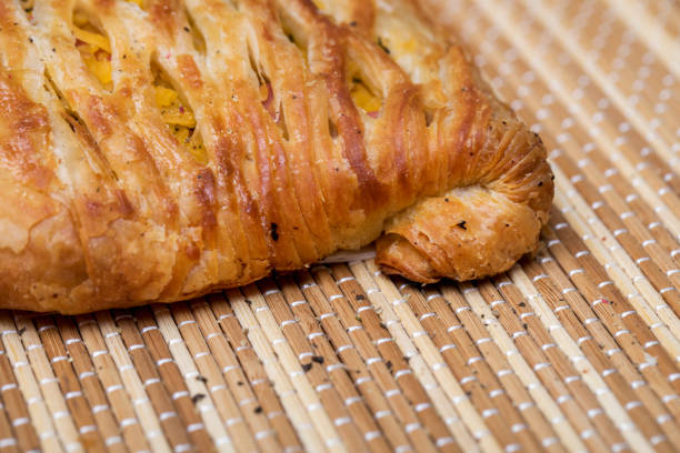 Puff pastry with vegetables and meat, sprinkled with black pepper.