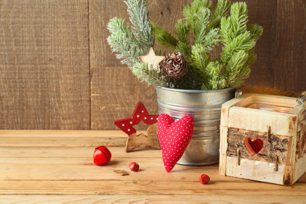 Christmas holiday background with pine tree branches, ornaments and candle decor on wooden table. Winter greeting card.