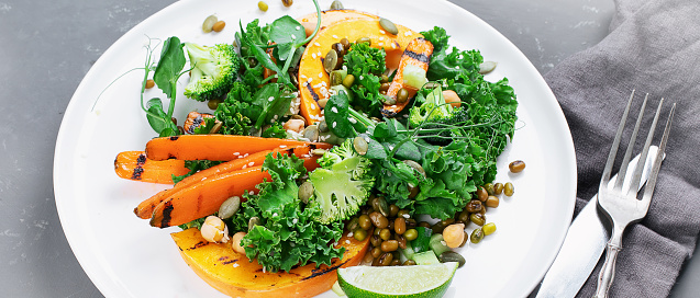 Grilled pumpkin salad with vegetables. Healthy vegan food. Top view, copy space