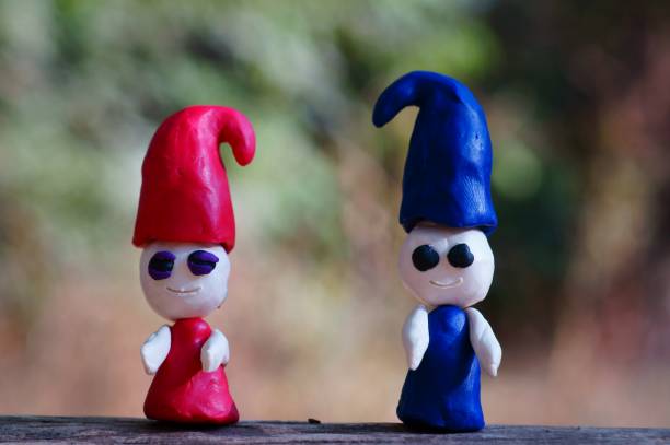 istock Two plasticine dwarfs in the forest on a colored background. 1285642186