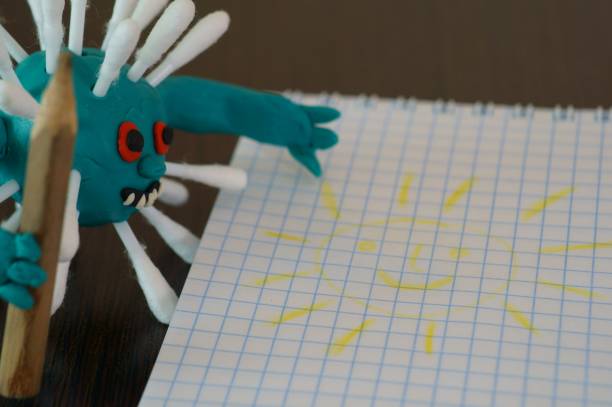 istock Virus figurine made of plasticine with a pencil. 1285642214