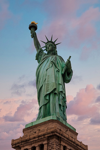 Statue of Liberty against dramatic sunset sky, Liberty Island, New York City