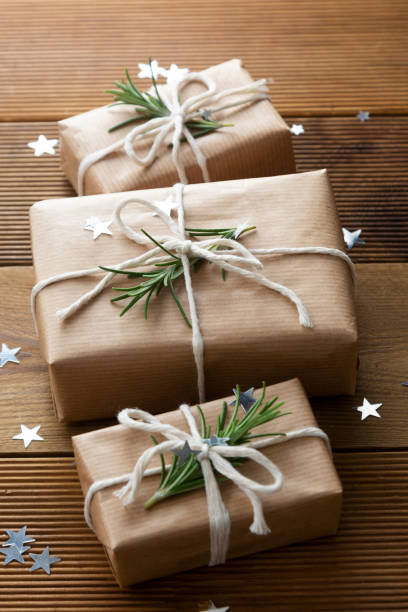 istock Christmas gift boxes wrapped with brown kraft paper over wooden background. Top view. 1285642536