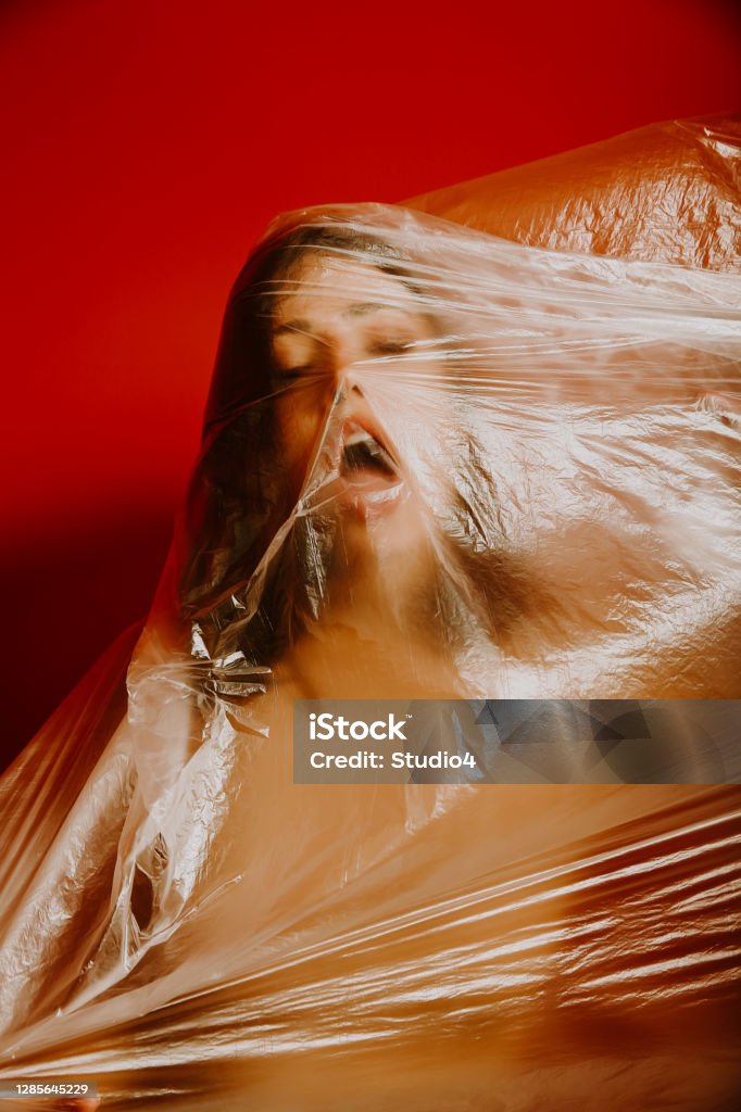 I can’t breathe A beautiful young woman covered and wrapped with a transparent plastic bag. Environmental protection concept Anti-racism Stock Photo