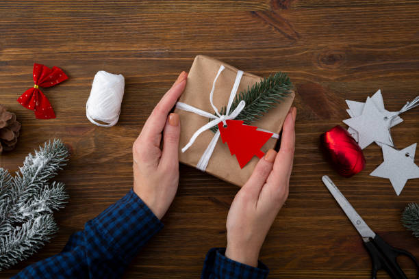 istock Present box in hands and Christmas decorations 1285647808
