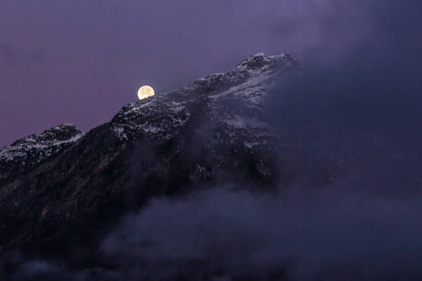 The moon setting behind the mountains in North Cascades National Park (Washington).
