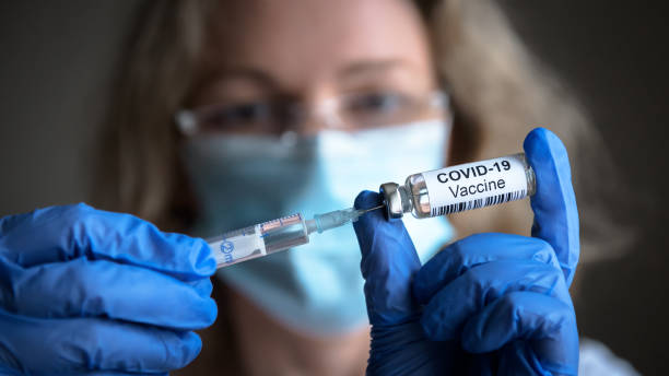 COVID-19 coronavirus vaccine in doctor hands COVID-19 vaccine in researcher hands, female doctor holds syringe and bottle with vaccine for coronavirus cure. Concept of corona virus treatment, injection, shot and clinical trial during pandemic. sending photos stock pictures, royalty-free photos & images