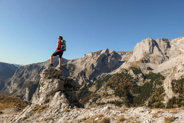 istock Hochschwab - A woman standing at a sharp and narrow rock 1285654549