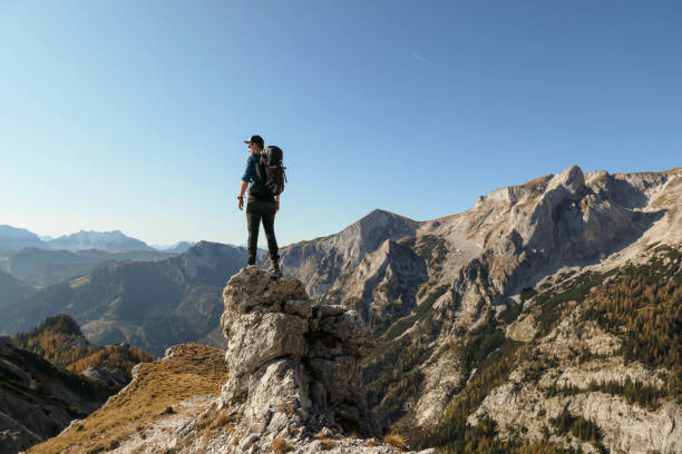 istock Hochschwab - A man standing at a sharp and narrow rock 1285654565