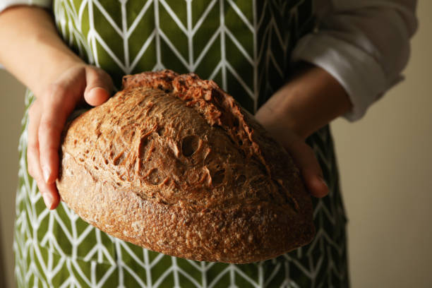 istock Woman in apron hold fresh baked bread 1285655071