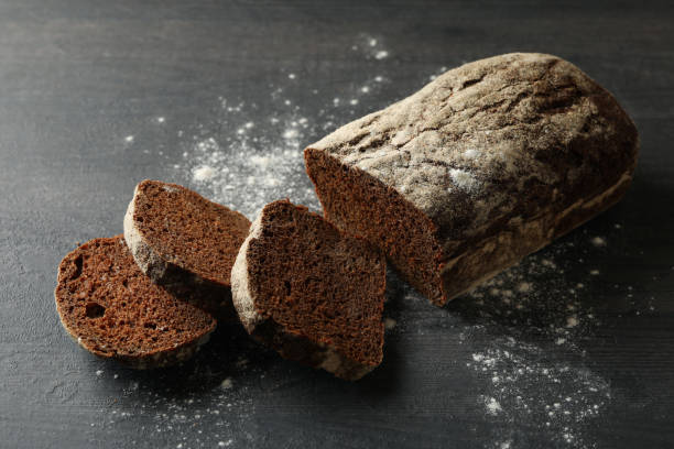 istock Fresh baked rye bread and flour on black background 1285655124