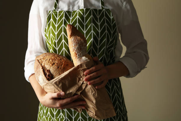 istock Woman in apron hold fresh baked bread 1285656063