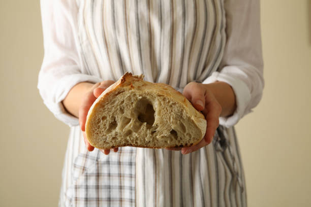 istock Woman in apron hold fresh baked bread 1285656139
