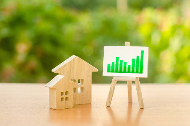 duas casas de madeira e uma boa tendência positiva verde no cavalete. aumento do valor imobiliário. aumento dos preços da habitação, manutenção predial. oferta e demanda. altas taxas de construção, alta liquidez. - apartment moving up tall growth - fotografias e filmes do acervo