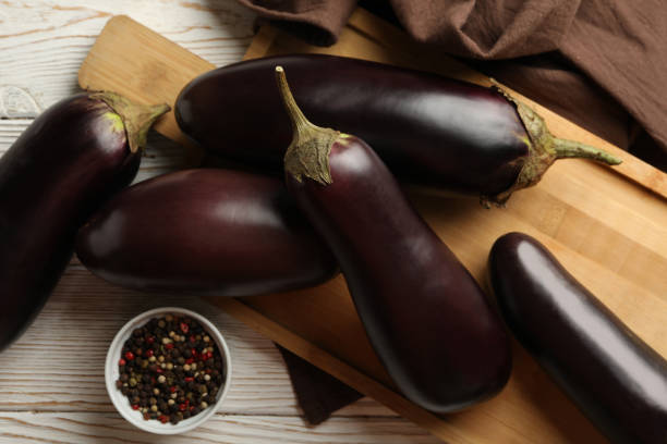 istock Board with eggplants and spices on white wooden background 1285657580