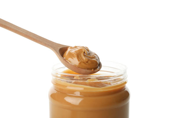 istock Jar and spoon with peanut butter isolated on white background 1285658689