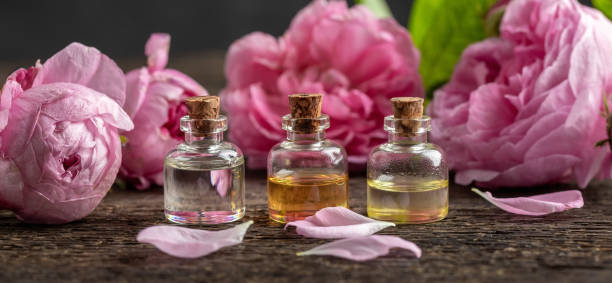 istock Panoramic header of three essential oil bottles with rose de mai flowers 1285667733