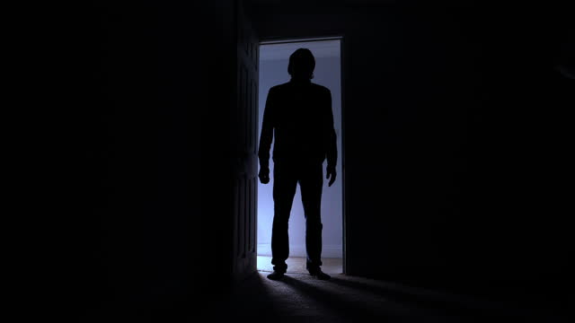 Silhouette of man standing in doorway - opens door