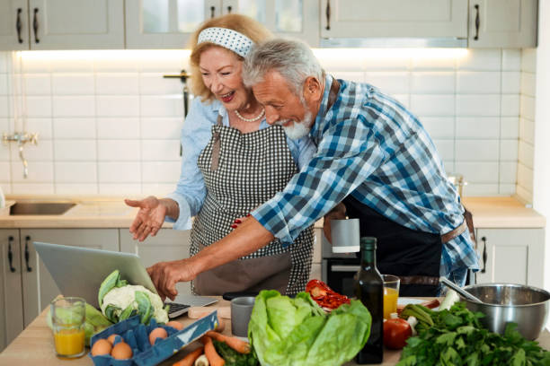 istock Senior couple watching video recipes on laptop at kitchen 1285673512