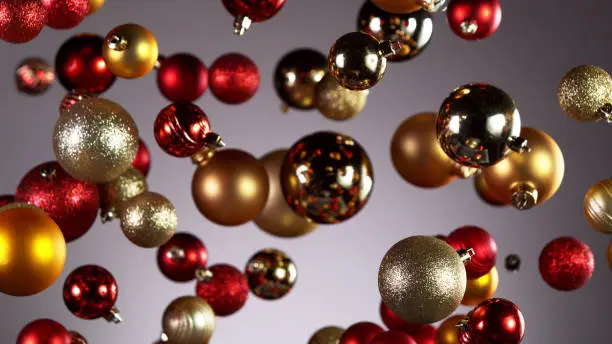 Flying christmas balls on coloured background, concept of celebrating, studio shot.