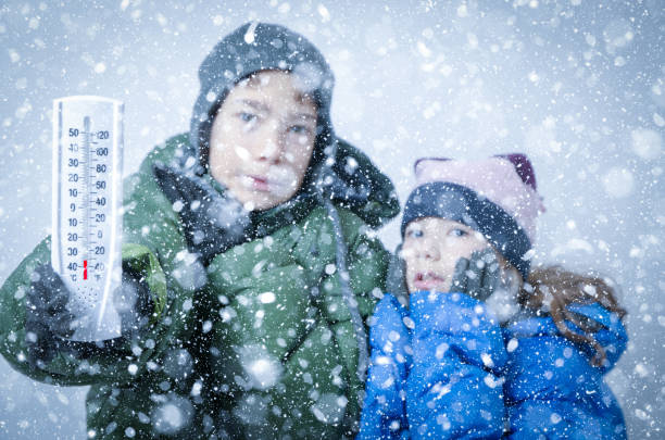 deux gosses gelant dans la tempête de neige - elementary age focus on foreground indoors studio shot photos et images de collection