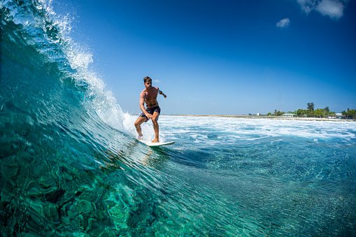 Surfer rides ocean wave in tropics